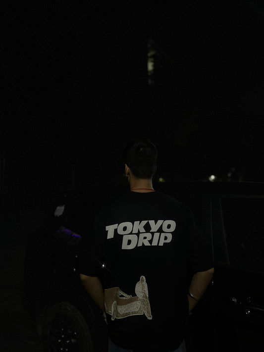 Person wearing a 'Tokyo Drip' shirt in a dark setting